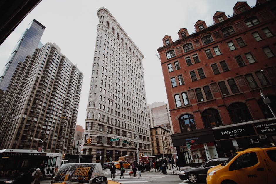Dramatic cityscape view of New York's iconic Flatiron Building amidst bustling street traffic