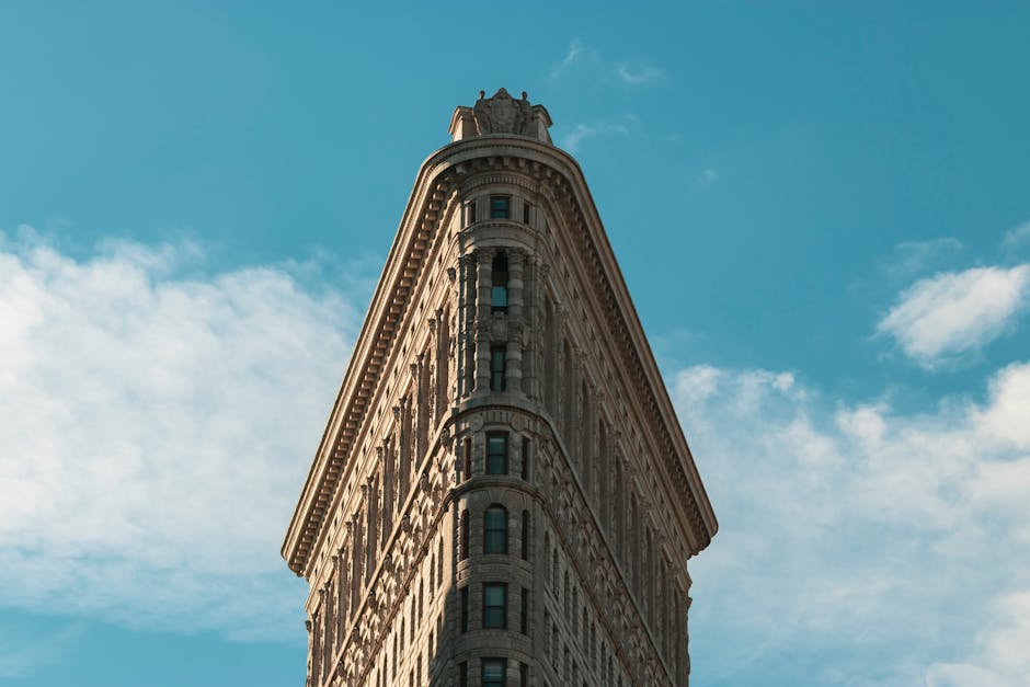 Flatiron Building in New York City under a bright sky, showcasing its unique architecture